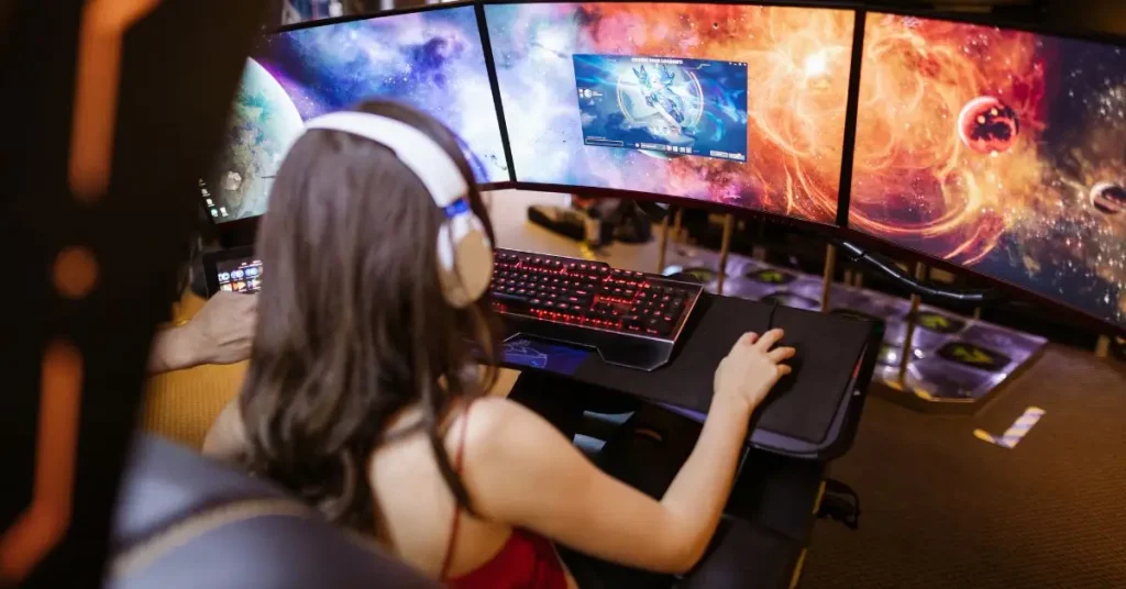  “Triple-monitor gaming setup using curved screens, showing a gamer with headphones playing on a high-performance PC.”